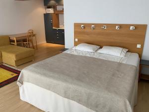 a bedroom with a large bed and a table at KURESSAARE TALLINN STREET APARTMENTs in Kuressaare