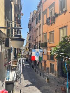 a city street with clotheslines with flags hanging from buildings at Caterina 70 in Naples