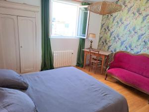 a bedroom with a bed and a red couch at Loft de charme, idéalement situé in La Ciotat +7 photos