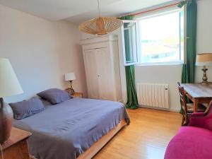 a bedroom with a bed and a table and a window at Loft de charme, idéalement situé in La Ciotat