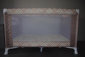 a bed in a crib with a net at Mucenieku Apartamenti in Kuldīga