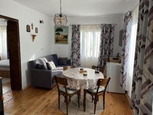 sala de estar con mesa, sillas y sofá en Miracle Houses Къщи за гости Чудеса, en Varshets