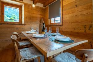 une salle à manger en bois avec une table et des chaises en bois dans l'établissement Appartamento NeveSole, à San Vito di Cadore