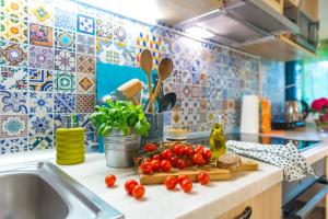 un comptoir de cuisine avec des tomates sur une planche de découpe à côté d'un évier dans l'établissement Boho House 4 in camp Terme Catez, à Čatež ob Savi