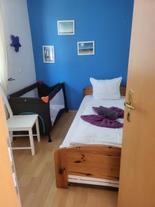 een blauwe kamer met een bed en een stoel bij Bungalow Usedom in Ostseebad Koserow