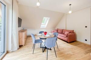 uma sala de estar com uma mesa e cadeiras e um sofá em Apartament Ptasi Śpiew 2 em Rabka