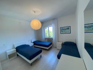 a bedroom with two beds and a pendant light at Centrale a 100 metri dal mare in Lignano Sabbiadoro