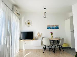 a dining room with a table and chairs and a tv at Apartments Babić in Trogir