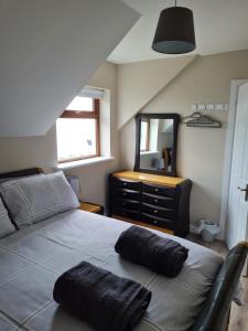 a bedroom with a bed and a dresser with a mirror at sea view apartment in Letterkenny