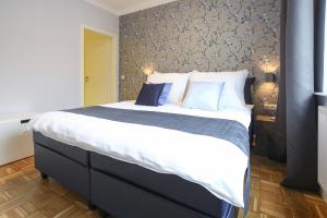 a bedroom with a large bed with blue and white pillows at Green Mango City Condo in Vienna