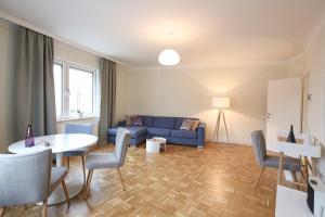 a living room with a blue couch and a table and chairs at Green Mango City Condo in Vienna