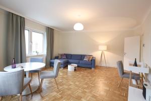 ウィーンにあるGreen Mango City Condoのリビングルーム(青いソファ、テーブル、椅子付)