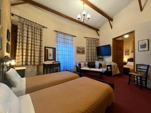 アラコバにあるPension Mariaのベッド2台とリビングルームが備わるホテルルームです。