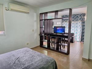 a bedroom with a bed and a flat screen tv at Departamentos Serena in Puerto Iguazú