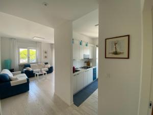 un soggiorno bianco con cucina e un soggiorno di Centrale a 100 metri dal mare a Lignano Sabbiadoro