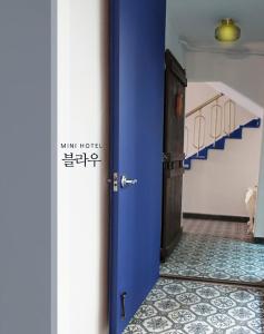 慶州市にあるBlau Guesthouseの廊下付きの部屋の青いドア