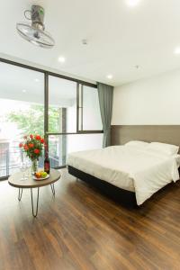 - une chambre avec un grand lit et une table dans l'établissement The Carnation Apartment 02, à Hanoï