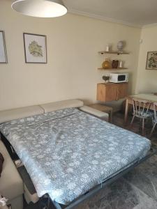 a bedroom with a bed with a blue blanket on it at Apartamento Los Vencejos in Ruidera