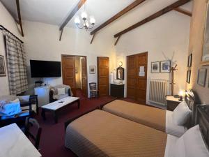 a bedroom with two beds and a living room at Pension Maria in Arachova