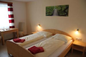 a bedroom with a bed with two pillows on it at Pension Merkinger in Behamberg