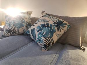 a couch with two pillows with palm trees on it at Arístides Azul in Mendoza