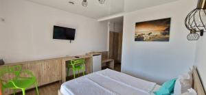 a bedroom with a bed and a tv on a wall at Jovis Domus in Eforie Sud