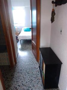 a hallway with a room with a bed and a black table at Habitaciones playa de Gandía in Playa de Gandia