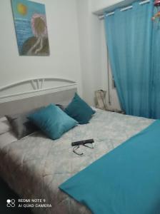 a bedroom with a bed with a blue curtain at Habitaciones playa de Gandía in Playa de Gandia