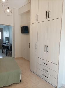 a bedroom with a large white cabinet and a table at Zeta ' s house in Nafpaktos