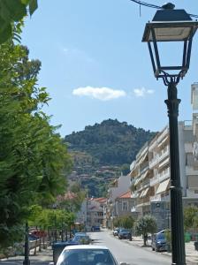a street light on a city street with a mountain at Zeta ' s house in Nafpaktos