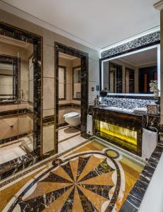 Narcissus Riyadh Hotel & Spa في الرياض: حمام مع مرآة كبيرة ومغسلة