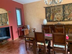 une salle à manger avec une table et une cheminée dans l'établissement Remarkable 6 bedrooms Villa in Cerrione with land, à Cerrione