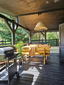 a wooden deck with a picnic table and a grill at Weranda & bania Siemiany in Siemiany