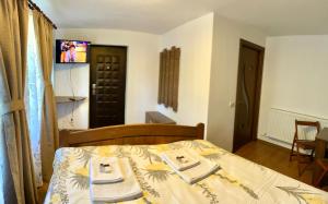 a bedroom with a bed with two towels on it at Casa de sub Salcie in Curtea de Argeş