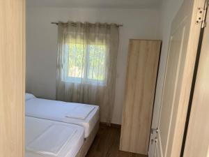 een kleine slaapkamer met een bed en een raam bij Niki Apartments in Ulcinj