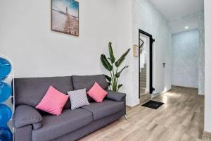 sala de estar con sofá gris y almohadas rosas en Umihouse apartamentos centro Alicante, en Alicante