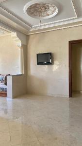 ein Wohnzimmer mit einem TV an der Wand in der Unterkunft Welcome to Big BL's house, Close to Tanger Med in Ksar es-Seghir