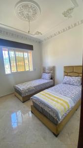1 Schlafzimmer mit 2 Betten und einer Decke in der Unterkunft Welcome to Big BL's house, Close to Tanger Med in Ksar es-Seghir