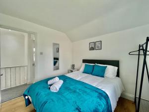 a bedroom with a large bed with blue sheets at Modern 3 Bed Romford Home (Free Parking) in Havering atte Bower