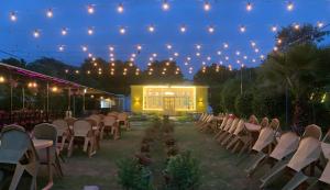 un set para una boda con sillas y luces en Agra Camps and Resort, en Agra