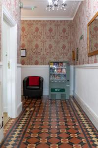 - un salon avec un réfrigérateur et une chaise dans l'établissement The Cadnant Holiday House, à Llandudno