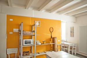 a room with a yellow wall with a microwave at Agriturismo Beatilla in Marmirolo