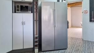 einen Kühlschrank aus Edelstahl in einer Küche mit weißen Schränken in der Unterkunft LookOut Ramsgate in Ramsgate