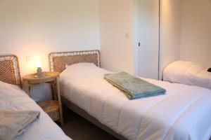 a room with two beds and a table with a lamp at La dunette : loft vue imprenable in Réville