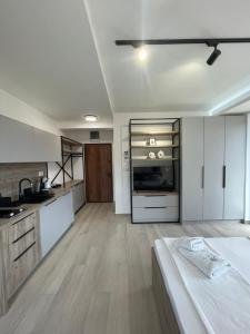 a kitchen with white cabinets and a bed in a room at Dora Family Apartments Budva in Budva