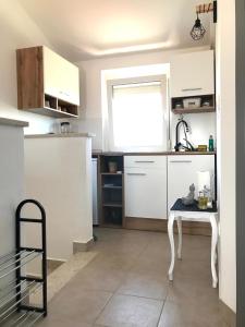 a kitchen with white cabinets and a table in it at SMOKVICA in Savudrija