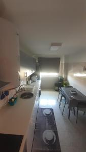 uma cozinha com um lavatório e uma mesa num quarto em GreenSea em Peniche