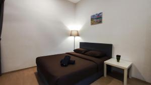 a bedroom with a bed and a table with a lamp at A ONE Holiday Apartment-Quintet in Cameron Highlands