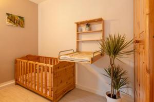 - une chambre avec un lit bébé et une plante dans l'établissement Ferienwohnung Airone Nero, à Gerolstein