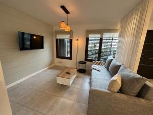 a living room with a couch and a table at Amplio departamento de diseño en el centro de SMA. 6C in San Martín de los Andes